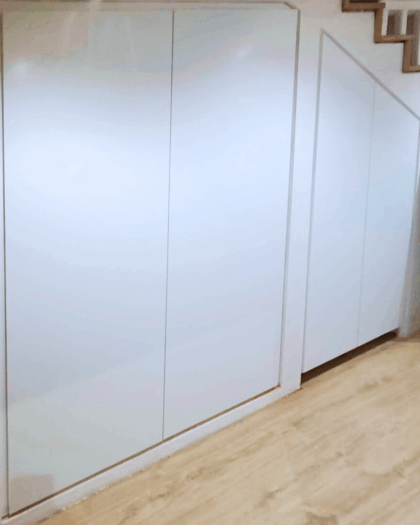 Armario empotrado a medida bajo escalera lacado en blanco mate en Cantabria por Veta Norte